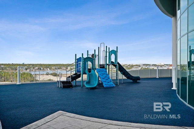 communal playground with fence and a water view