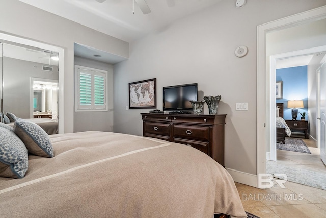 bedroom with visible vents, ensuite bathroom, light tile patterned floors, baseboards, and ceiling fan