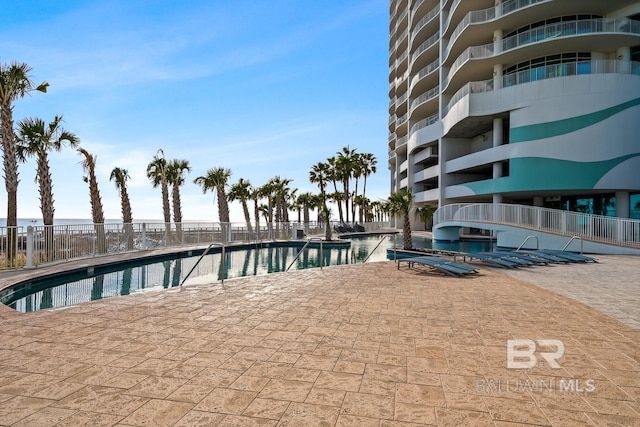 pool with a patio and fence