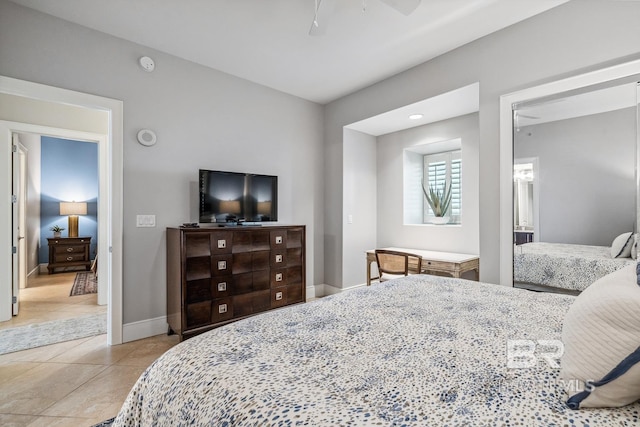 bedroom with light tile patterned floors, a ceiling fan, and baseboards