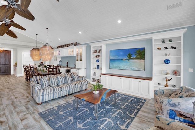 living room featuring built in features, light hardwood / wood-style flooring, and ceiling fan