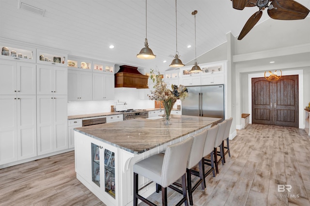 kitchen featuring premium range hood, light hardwood / wood-style floors, white cabinetry, built in refrigerator, and a large island