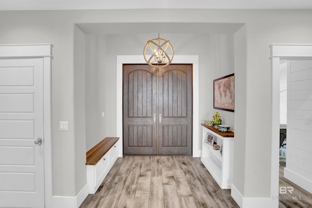 foyer entrance featuring light hardwood / wood-style flooring and a chandelier