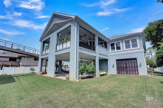 view of front facade featuring a garage, ceiling fan, and a front lawn