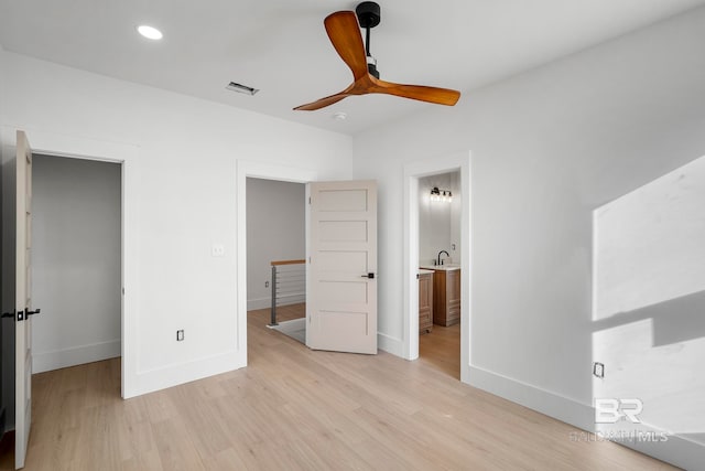 unfurnished bedroom featuring connected bathroom, ceiling fan, and light hardwood / wood-style flooring