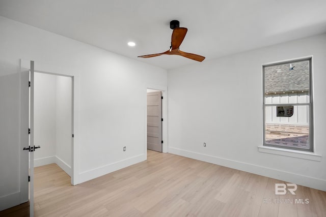 unfurnished bedroom with a spacious closet, light wood-type flooring, and ceiling fan