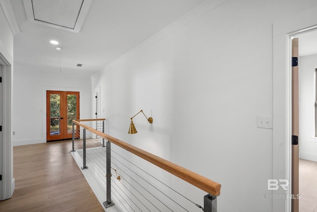 corridor featuring light hardwood / wood-style floors, french doors, and crown molding