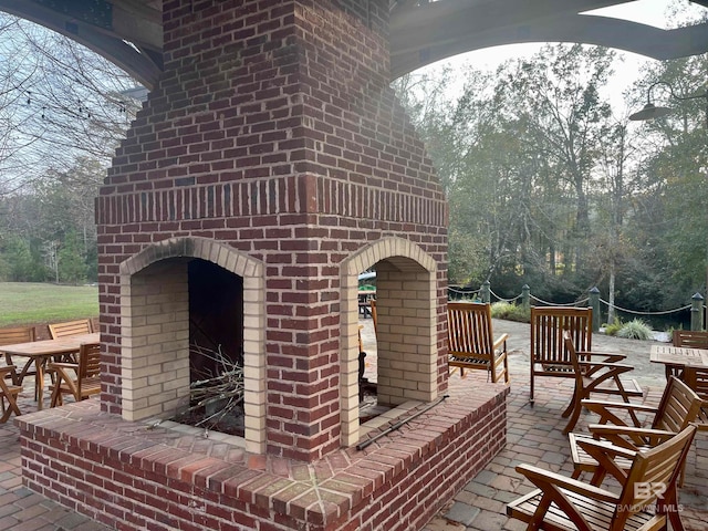 view of patio with an outdoor brick fireplace