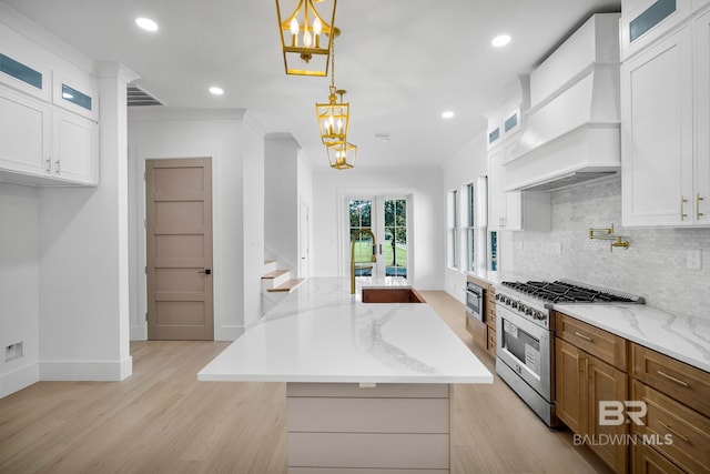 kitchen with white cabinetry, high end stainless steel range, and a kitchen island