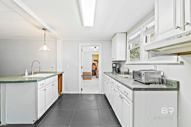 kitchen featuring ornamental molding, sink, white cabinetry, and decorative light fixtures