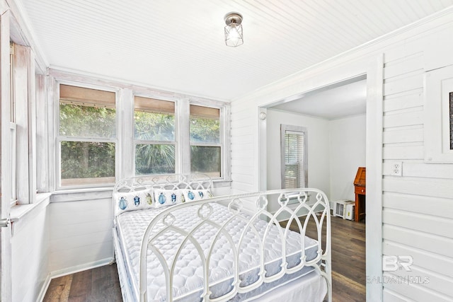 bedroom with ornamental molding and dark hardwood / wood-style flooring