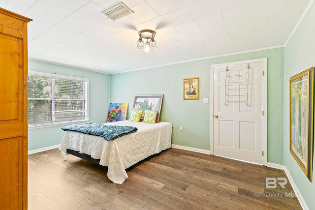 bedroom with hardwood / wood-style floors and crown molding