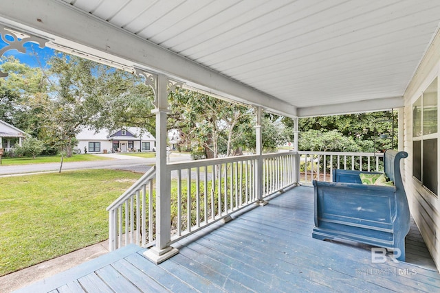 wooden terrace with covered porch and a lawn