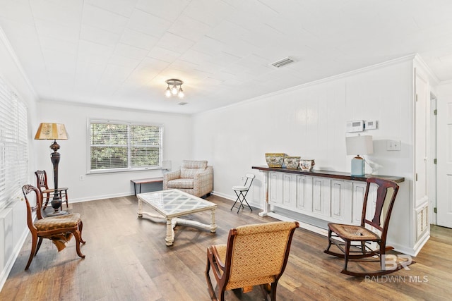 sitting room featuring crown molding and hardwood / wood-style flooring