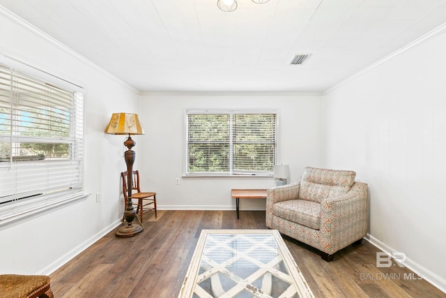 living area with crown molding, a wealth of natural light, and hardwood / wood-style floors