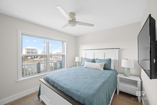 bedroom with ceiling fan, light wood-style flooring, and baseboards