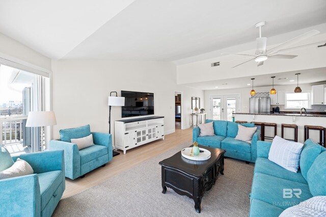 living room with visible vents, lofted ceiling, french doors, light wood-type flooring, and recessed lighting