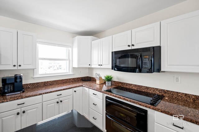 kitchen featuring dark stone counters, black appliances, and white cabinetry