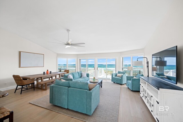 living area with a ceiling fan, vaulted ceiling, baseboards, and wood finished floors