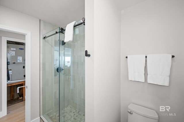 full bath featuring a shower stall and toilet