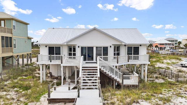 back of house featuring a deck, metal roof, and stairway