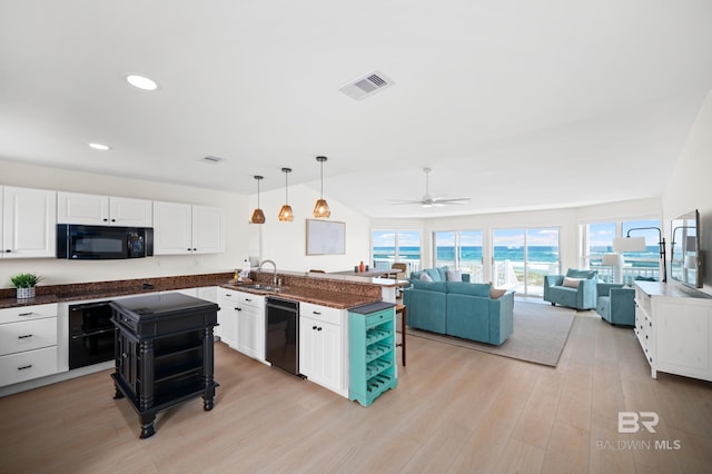 kitchen featuring visible vents, white cabinetry, light wood-type flooring, a peninsula, and black appliances