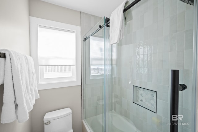 full bathroom featuring shower / bath combination with glass door and toilet