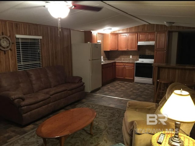 living room featuring lofted ceiling, sink, and wood walls