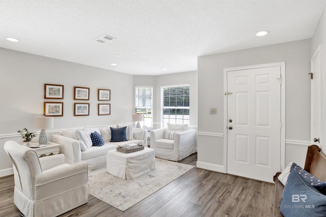 living room with wood-type flooring and a textured ceiling