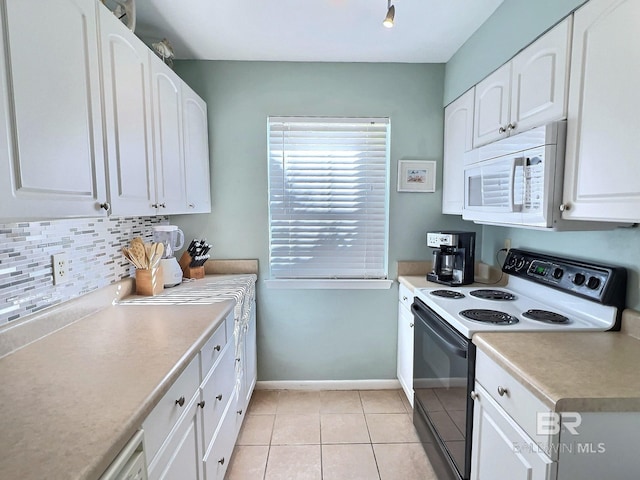 kitchen featuring light countertops, white cabinets, electric range oven, and white microwave