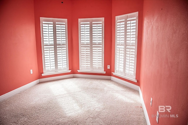 carpeted empty room with baseboards