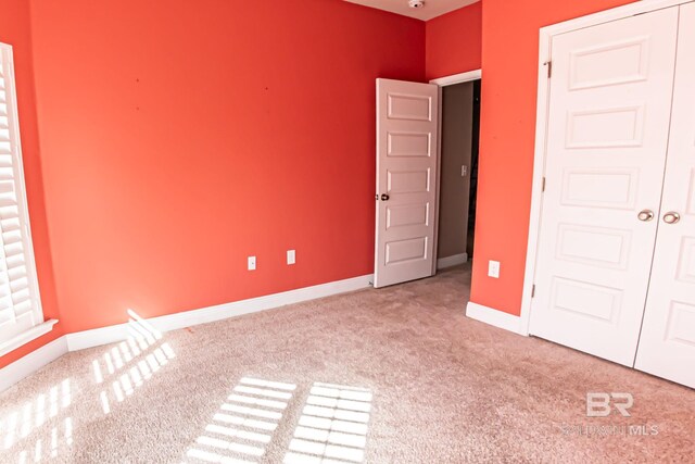 unfurnished bedroom featuring carpet and baseboards