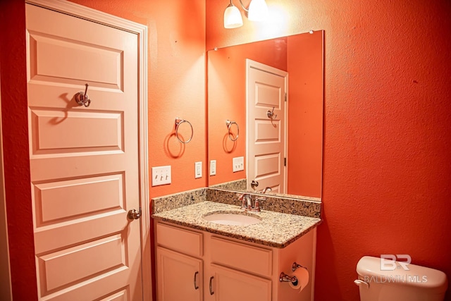 half bathroom with toilet and vanity