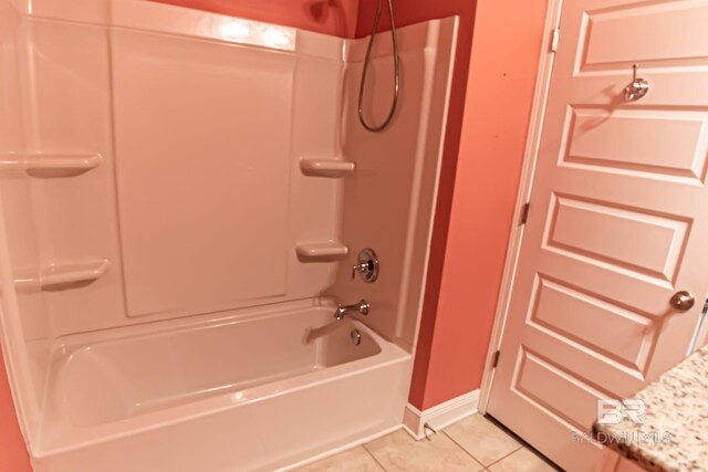 bathroom featuring baseboards, washtub / shower combination, and tile patterned floors