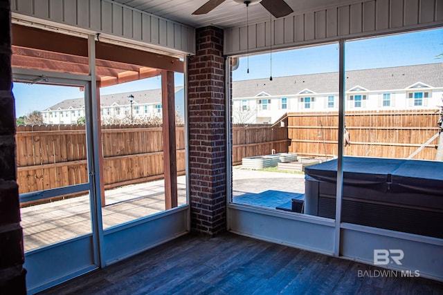 sunroom with a wealth of natural light, a residential view, and ceiling fan