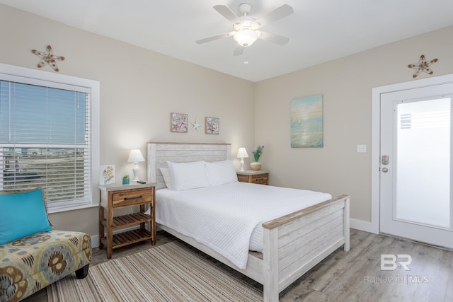 bedroom featuring baseboards, light wood-style floors, and a ceiling fan