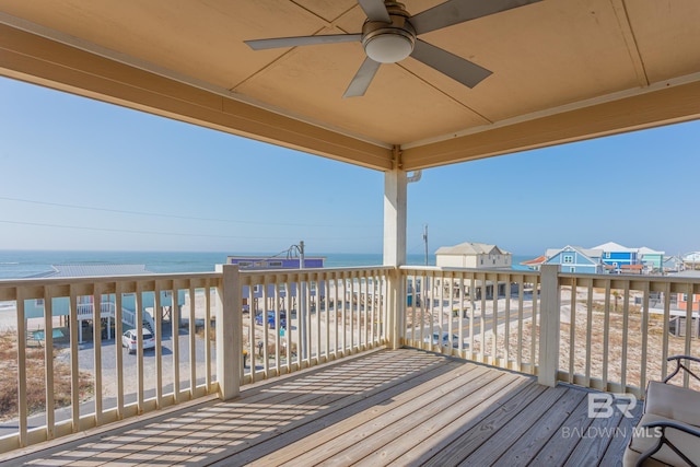 wooden deck with a water view and ceiling fan