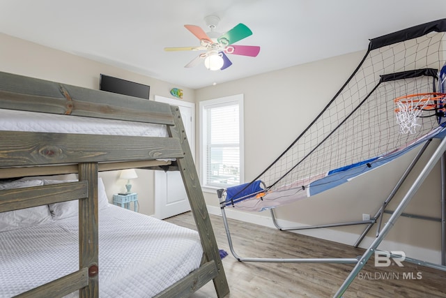 unfurnished bedroom featuring baseboards, wood finished floors, and ceiling fan