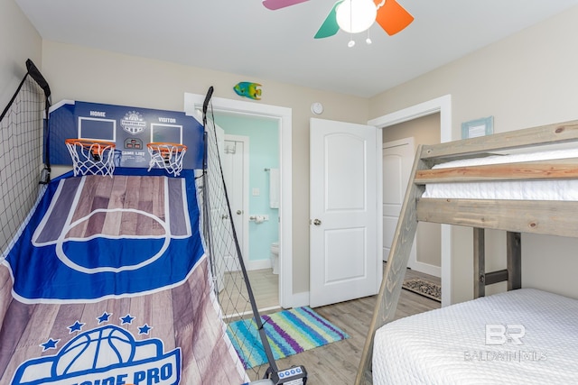 bedroom with ensuite bathroom, wood finished floors, and a ceiling fan