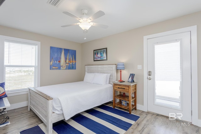 bedroom featuring baseboards, visible vents, wood finished floors, and ceiling fan