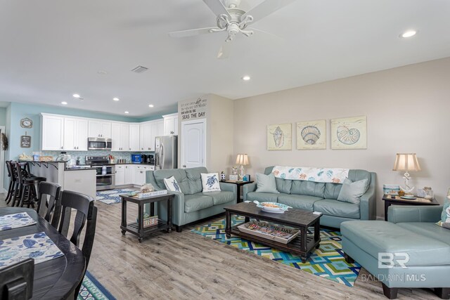 living room featuring visible vents, light wood-style flooring, recessed lighting, and a ceiling fan