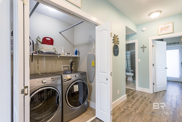 laundry room with baseboards, independent washer and dryer, laundry area, and wood finished floors