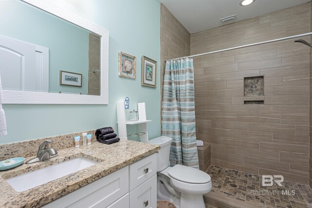bathroom featuring visible vents, toilet, recessed lighting, vanity, and tiled shower