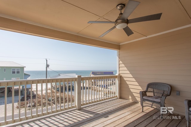 wooden deck with a water view and a ceiling fan