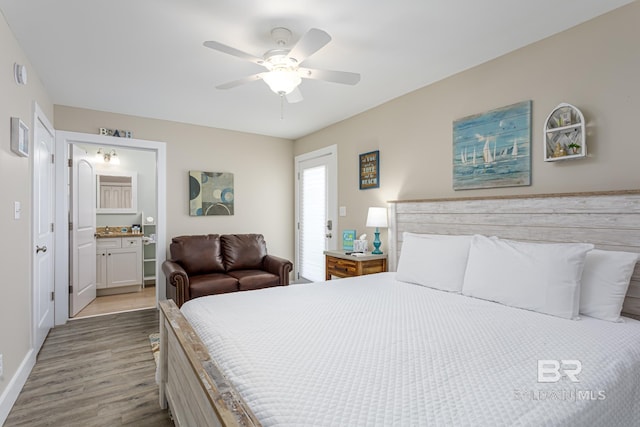 bedroom featuring baseboards, ensuite bath, wood finished floors, and a ceiling fan