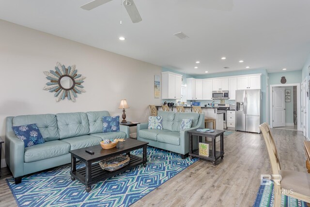 living room featuring visible vents, light wood-style floors, ceiling fan, and recessed lighting