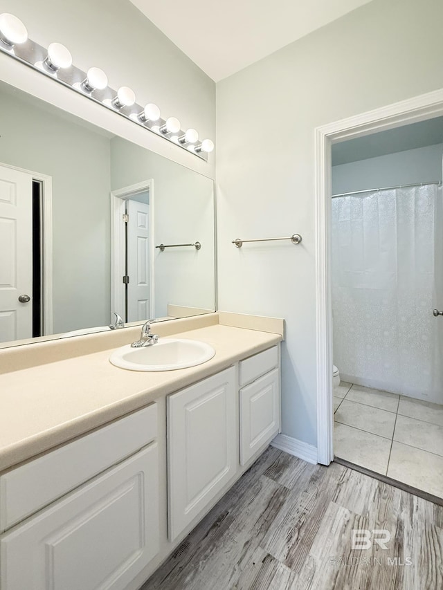 full bathroom featuring toilet, wood finished floors, and vanity
