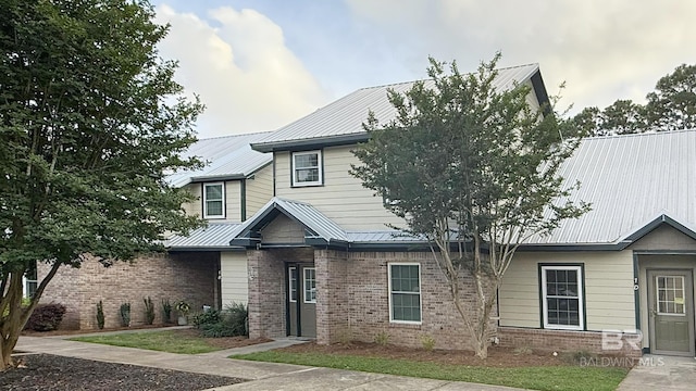 view of front facade with brick siding and metal roof
