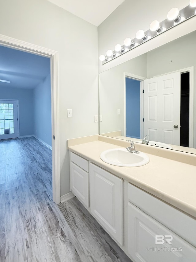 bathroom featuring vanity, baseboards, and wood finished floors
