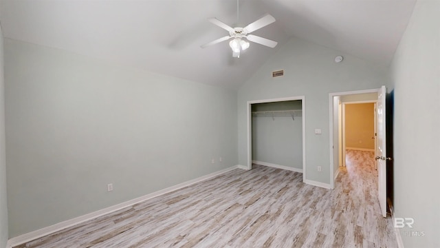 unfurnished bedroom with ceiling fan, high vaulted ceiling, baseboards, a closet, and light wood-style flooring